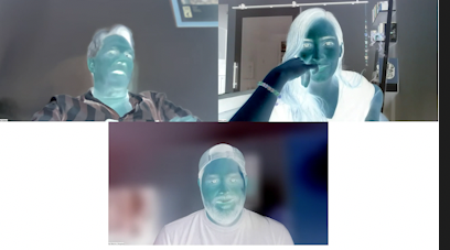 Detail photo of color negative effect. Image includes three people with the appearance of blue skin with white hair and clothing.
